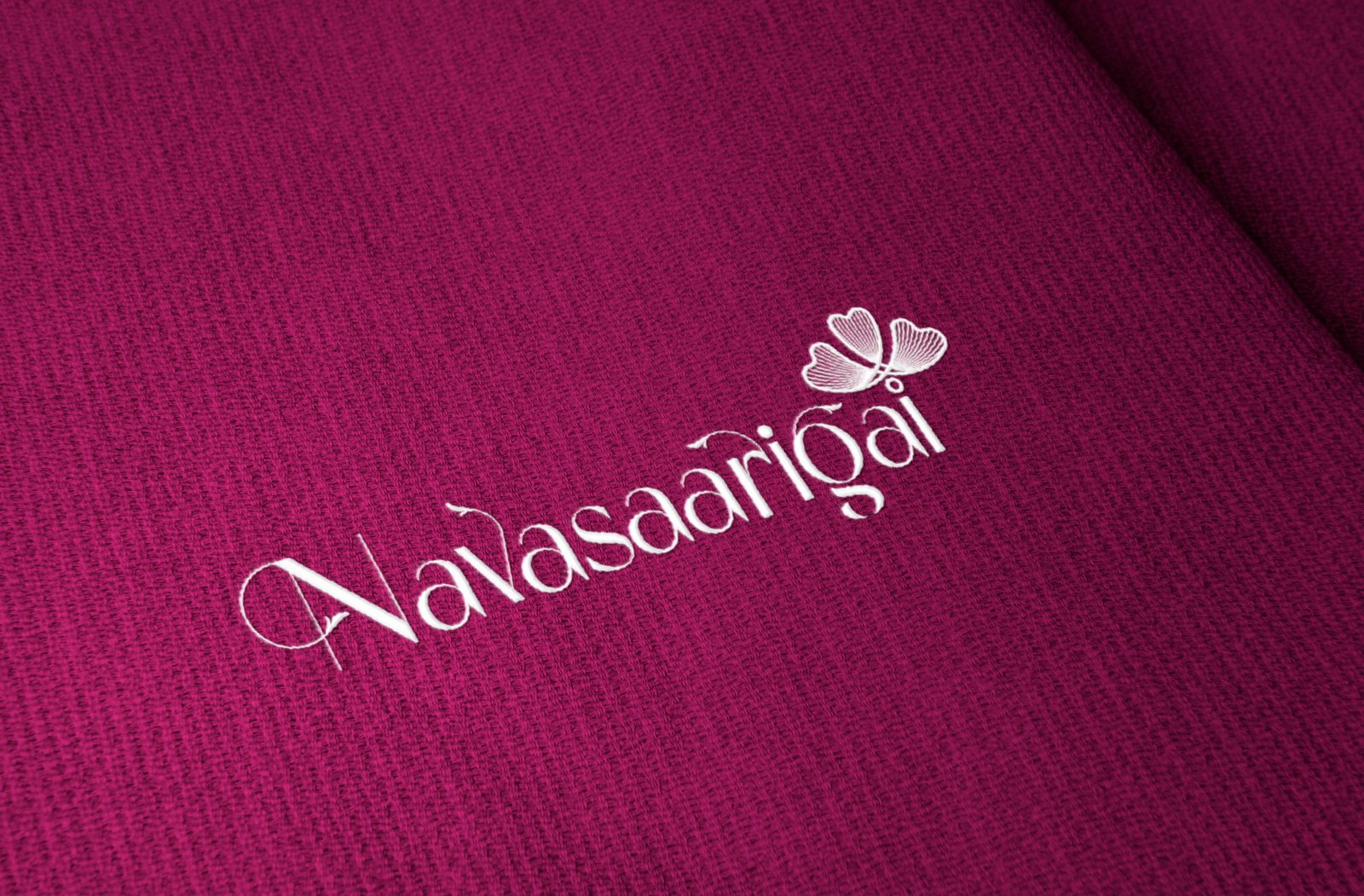 Elegant logo embossed on textured fabric background with minimal branding style.